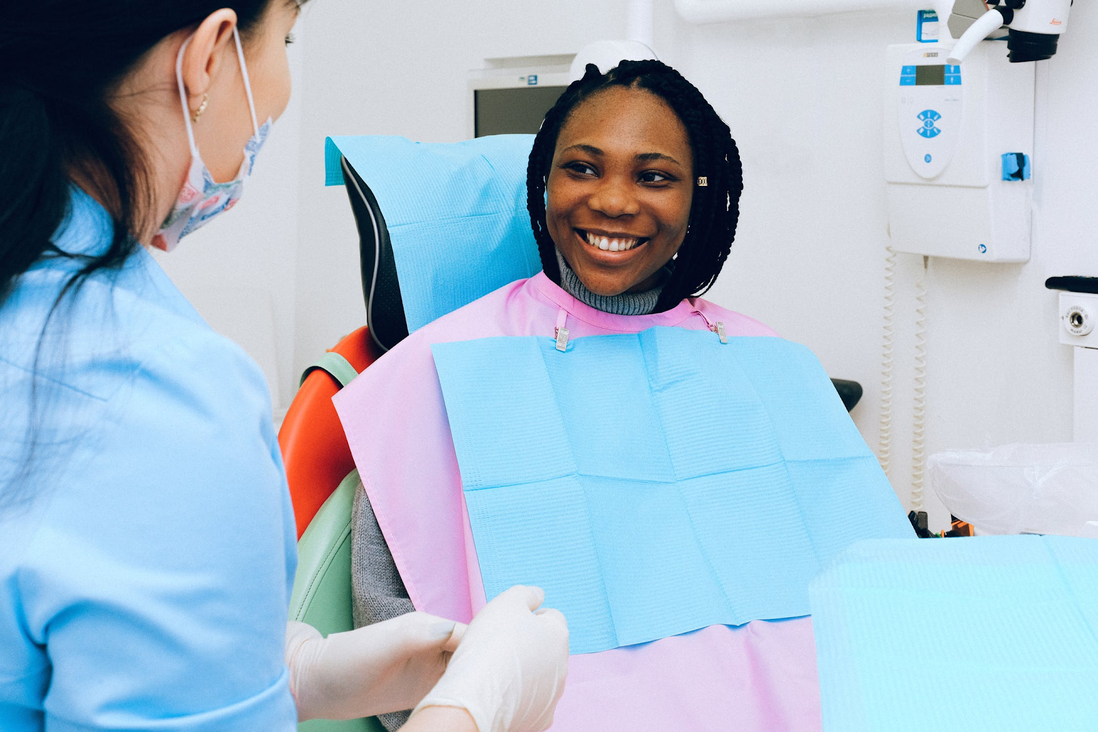 Family Dental Clinic - A young woman sitting in a dental chair smiling at the Dentist